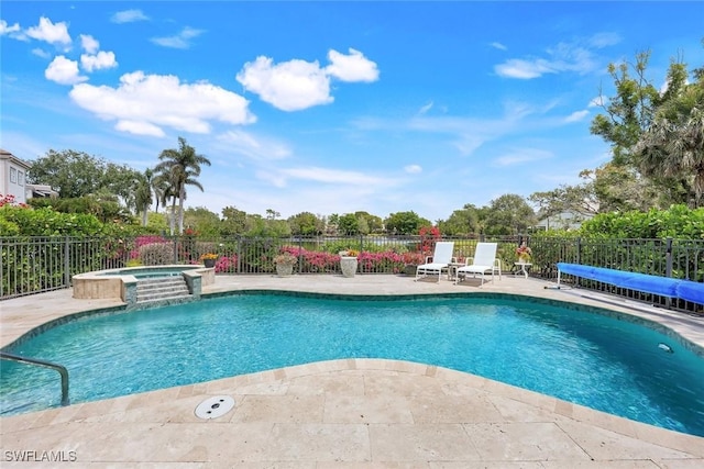 view of pool with a patio area, a pool with connected hot tub, and fence