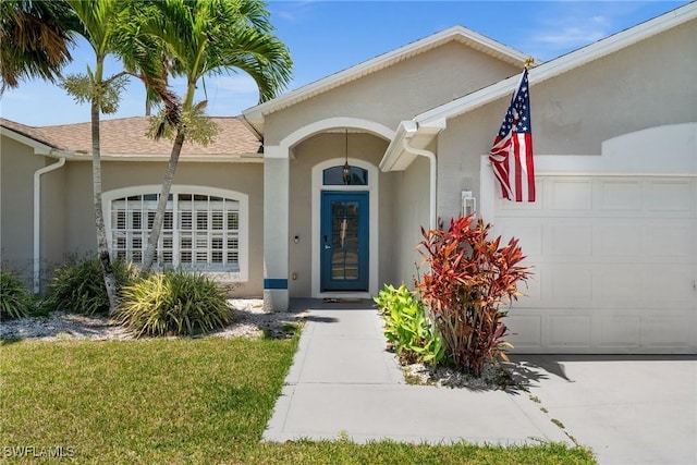 2017 Cape Coral Pkwy W, Cape Coral, FL 33914 - view of exterior entry with an attached garage, stucco siding, and roof with shingles