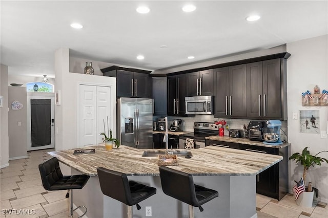 2017 Cape Coral Pkwy W, Cape Coral, FL 33914 - kitchen featuring appliances with stainless steel finishes, a breakfast bar area, light stone countertops, decorative backsplash, and recessed lighting