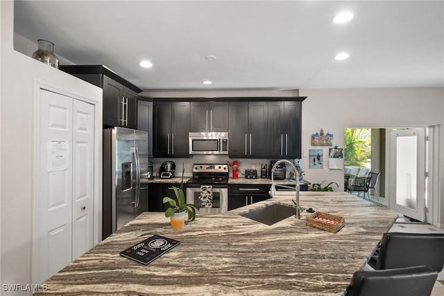 2017 Cape Coral Pkwy W, Cape Coral, FL 33914 - kitchen featuring stainless steel appliances, a sink, decorative backsplash, recessed lighting, and light stone counters