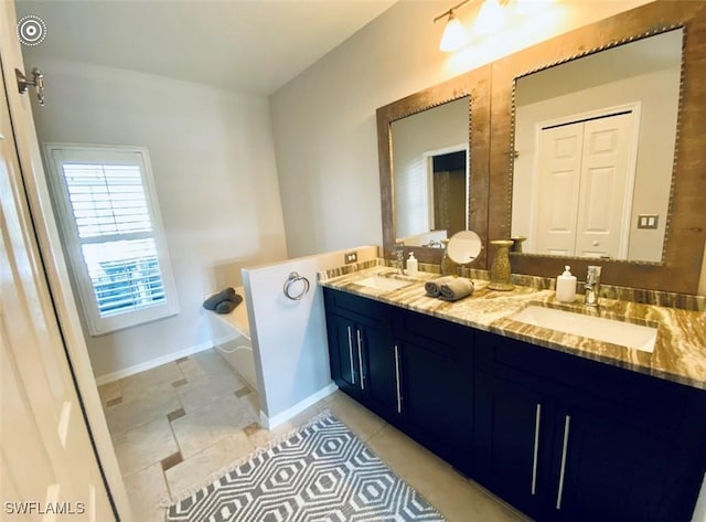 2017 Cape Coral Pkwy W, Cape Coral, FL 33914 - bathroom with double vanity, a bath, baseboards, and tile patterned floors