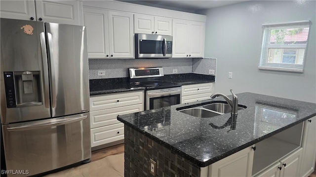 2357 Crawford St, Fort Myers, FL 33901 - kitchen with dark stone countertops, white cabinetry, a sink, stainless steel appliances, and backsplash