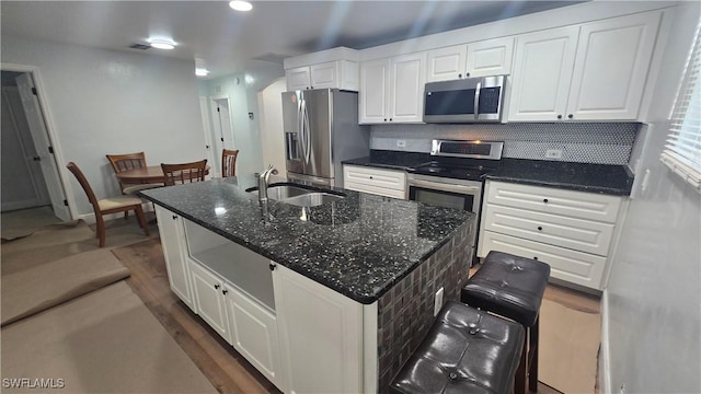 2357 Crawford St, Fort Myers, FL 33901 - kitchen with white cabinetry, decorative backsplash, visible vents, stainless steel appliances, and a kitchen island with sink