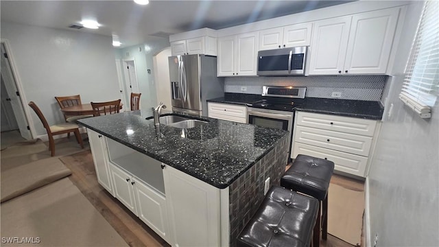 2357 Crawford St, Fort Myers, FL 33901 - kitchen with tasteful backsplash, stainless steel appliances, white cabinets, a sink, and a center island with sink