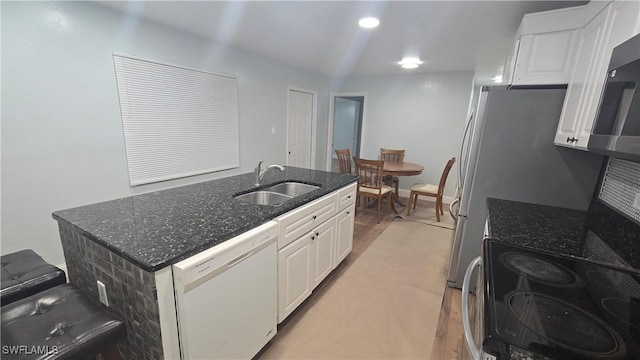 2357 Crawford St, Fort Myers, FL 33901 - kitchen featuring dark stone counters, white cabinets, a sink, dishwasher, and a center island with sink