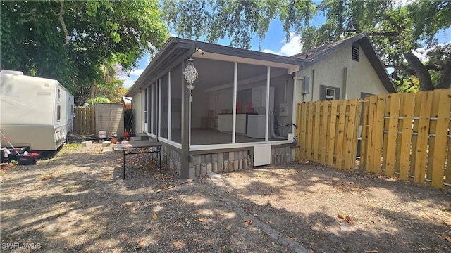 2357 Crawford St, Fort Myers, FL 33901 - view of side of home featuring fence, washer / dryer, stucco siding, and a sunroom
