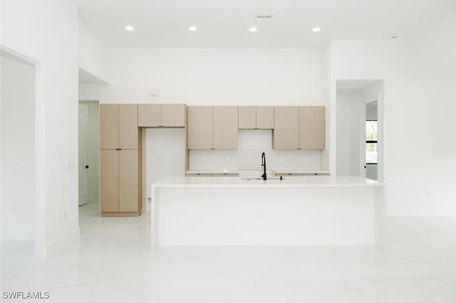 kitchen with light countertops, recessed lighting, a spacious island, and a sink