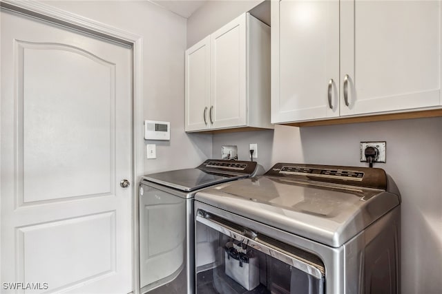 705 Columbus Blvd S, Lehigh Acres, FL 33974 - laundry area featuring washing machine and clothes dryer and cabinet space