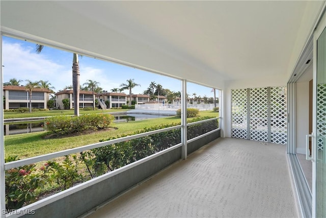 1155 Sandpiper St Unit E1, Naples, FL 34102 - unfurnished sunroom featuring a water view, plenty of natural light, and a residential view