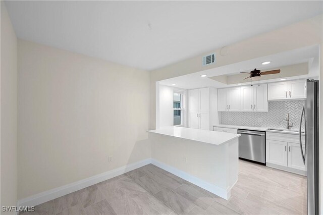 1155 Sandpiper St Unit E1, Naples, FL 34102 - kitchen featuring appliances with stainless steel finishes, white cabinetry, tasteful backsplash, ceiling fan, and light countertops