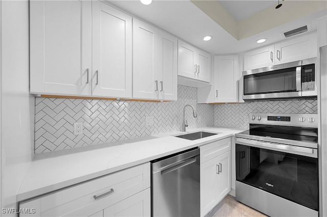 1155 Sandpiper St Unit E1, Naples, FL 34102 - kitchen featuring appliances with stainless steel finishes, recessed lighting, white cabinetry, and tasteful backsplash