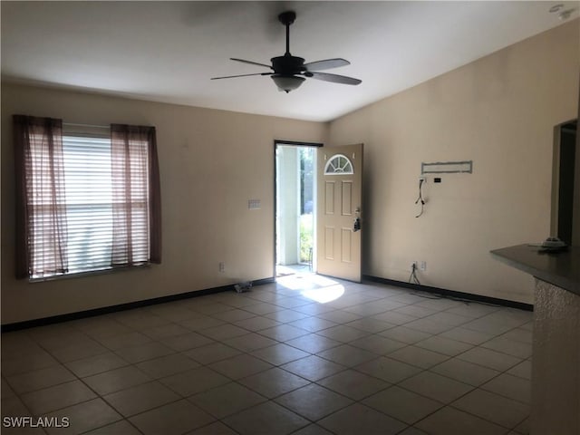 spare room with baseboards, a ceiling fan, and lofted ceiling