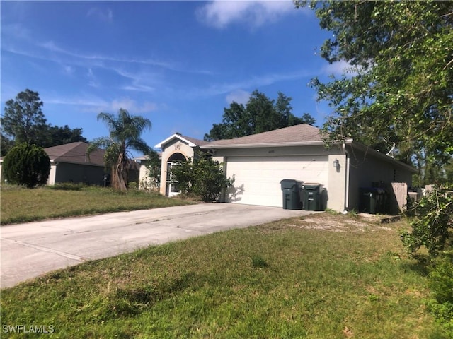 single story home with stucco siding, driveway, a front yard, and a garage