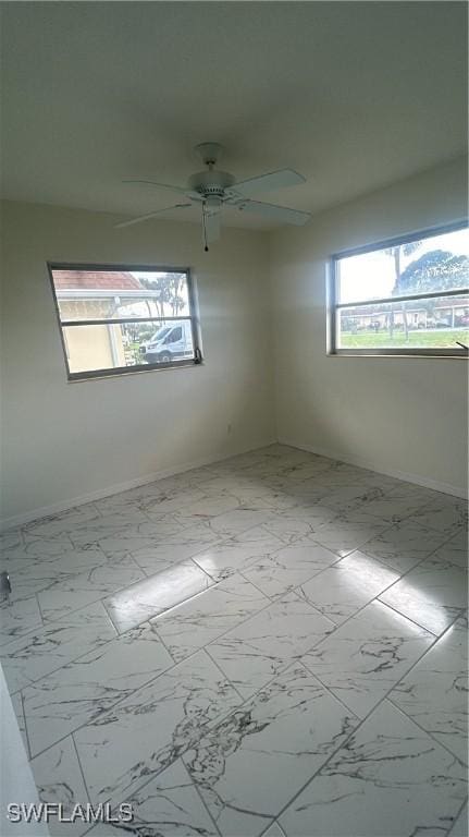 2213 Gardenia Way, Lehigh Acres, FL 33936 - empty room featuring marble finish floor, baseboards, and a ceiling fan
