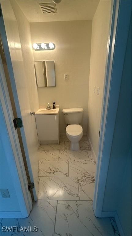 2213 Gardenia Way, Lehigh Acres, FL 33936 - bathroom featuring vanity, marble finish floor, baseboards, toilet, and visible vents