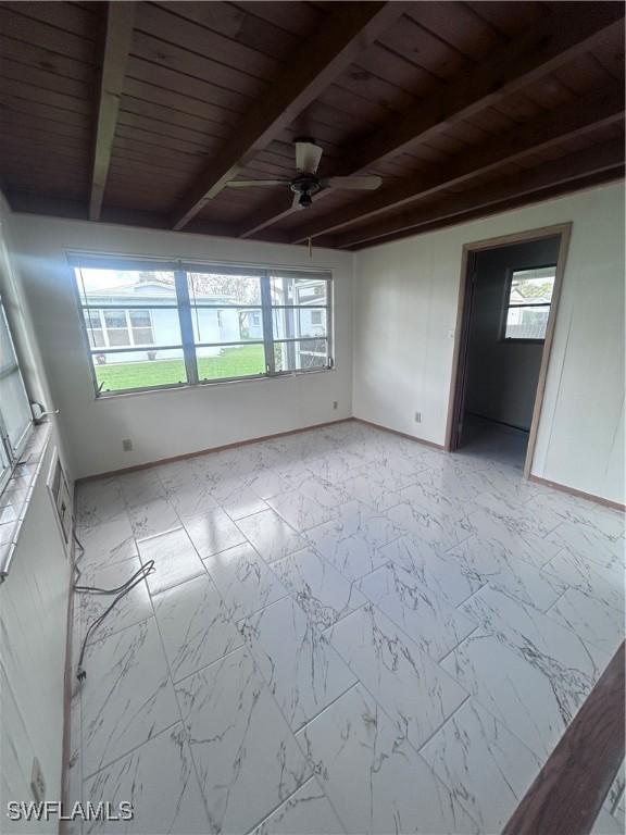 2213 Gardenia Way, Lehigh Acres, FL 33936 - unfurnished room featuring beam ceiling, marble finish floor, baseboards, and ceiling fan