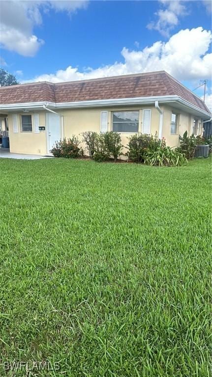 2213 Gardenia Way, Lehigh Acres, FL 33936 - exterior space featuring a lawn, a carport, and stucco siding