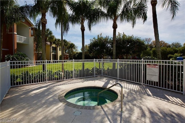 view of swimming pool with fence and a community hot tub