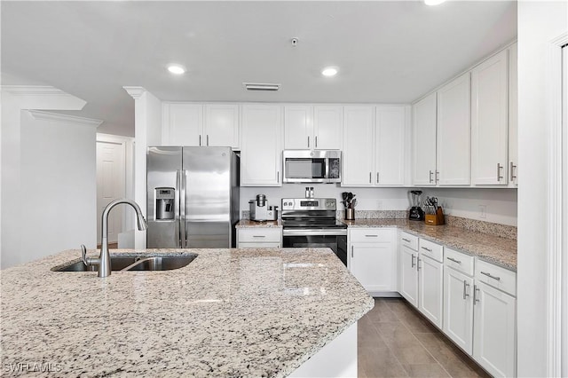 kitchen featuring visible vents, stainless steel appliances, white cabinets, and a sink