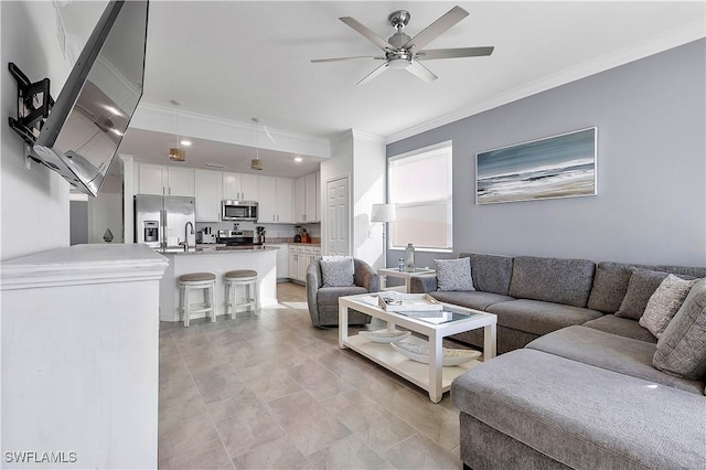 living room with ceiling fan and ornamental molding