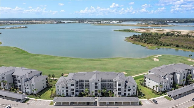 drone / aerial view with golf course view and a water view