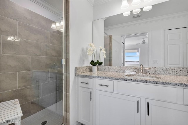 full bathroom with vanity, a shower stall, crown molding, and visible vents