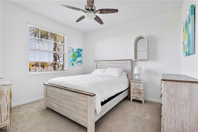bedroom featuring baseboards, a ceiling fan, and light colored carpet