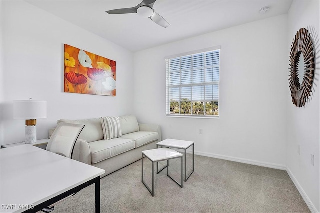 living area featuring carpet flooring, ceiling fan, and baseboards