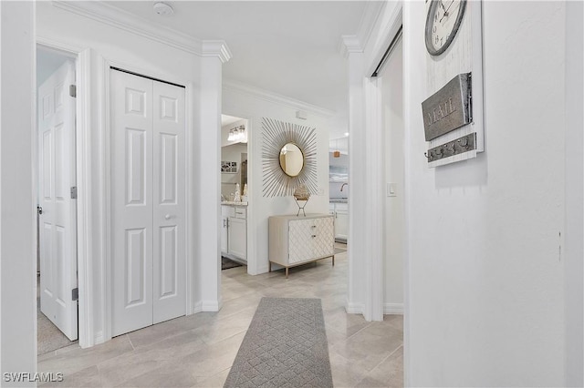 corridor featuring crown molding, light tile patterned flooring, and baseboards