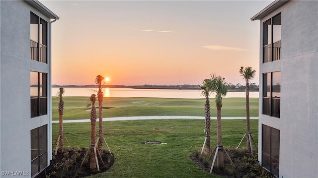 view of yard with a water view and view of golf course