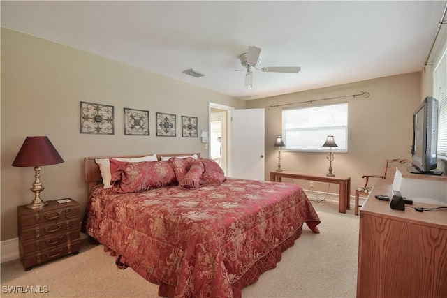 bedroom featuring visible vents, baseboards, a ceiling fan, and light carpet