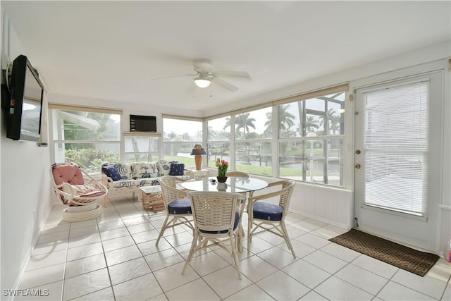 sunroom featuring tile patterned flooring and baseboards