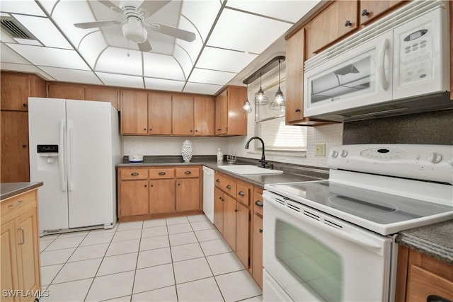 kitchen with a sink, ceiling fan, dark countertops, visible vents, and white appliances