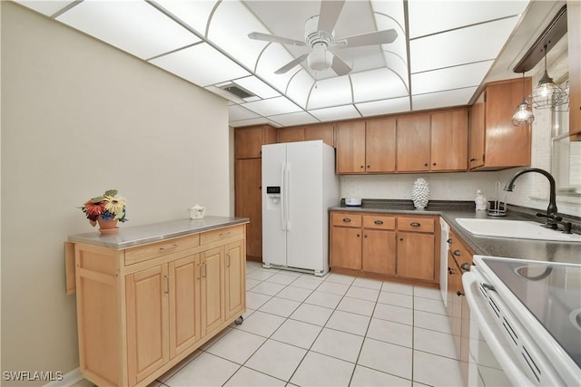 kitchen with light tile patterned floors, white fridge with ice dispenser, a sink, ceiling fan, and visible vents