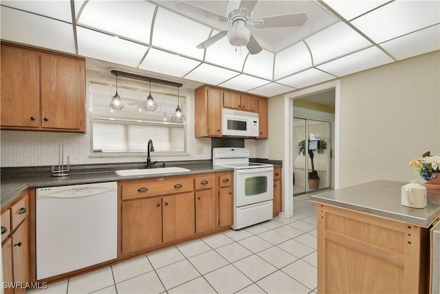 kitchen with dark countertops, white appliances, ceiling fan, and a sink