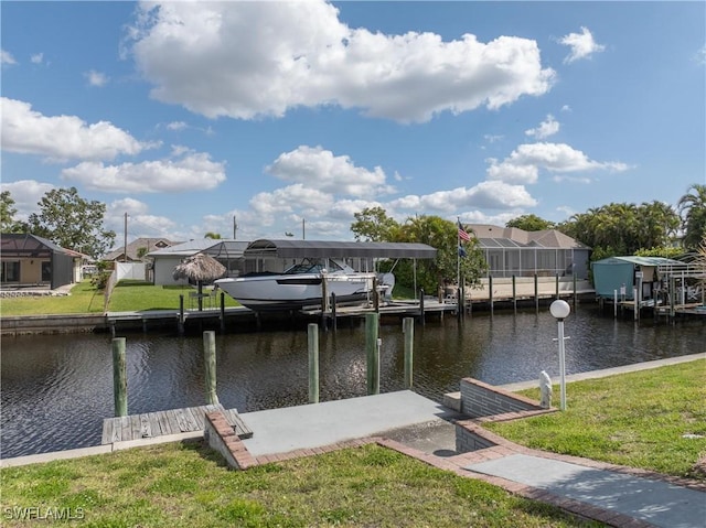 dock area featuring boat lift, a yard, a residential view, and a water view