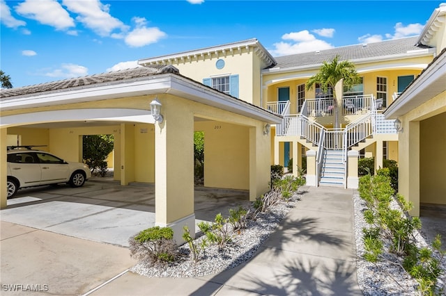 14524 Abaco Lakes Dr Unit 203, Fort Myers, FL 33908 - view of side of property with stucco siding, stairway, and a porch