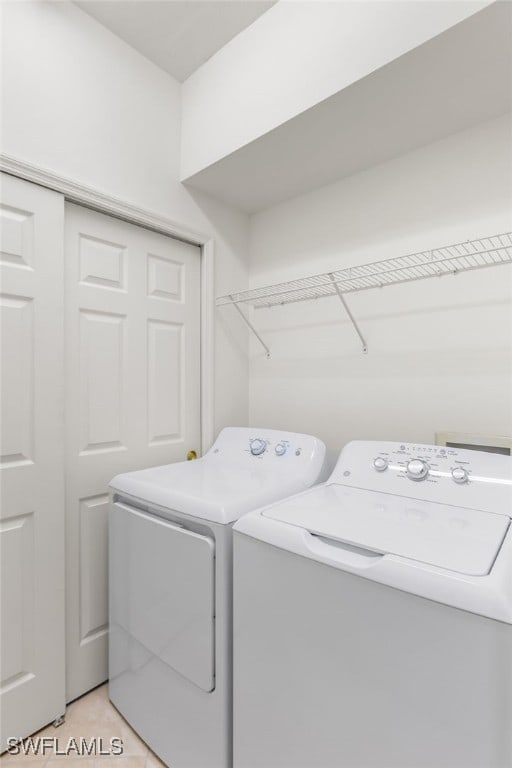 14524 Abaco Lakes Dr Unit 203, Fort Myers, FL 33908 - clothes washing area with separate washer and dryer, light tile patterned flooring, and laundry area