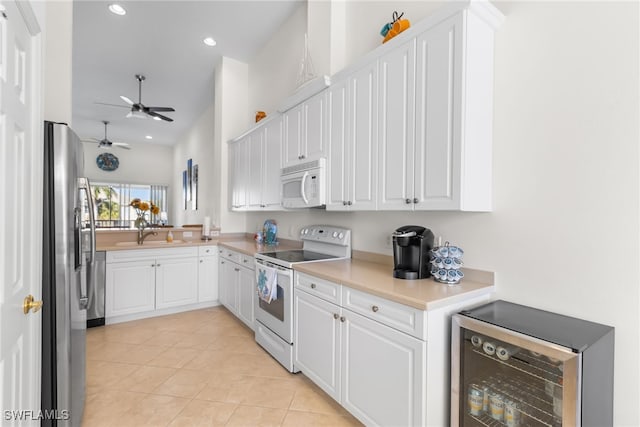 14524 Abaco Lakes Dr Unit 203, Fort Myers, FL 33908 - kitchen with wine cooler, white appliances, ceiling fan, white cabinetry, and light countertops