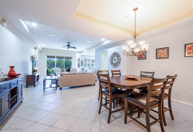 4630 Winged Foot Ct Unit 202, Naples, FL 34112 - dining room with light tile patterned floors, ceiling fan with notable chandelier, baseboards, and a tray ceiling