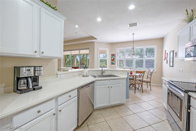 4630 Winged Foot Ct Unit 202, Naples, FL 34112 - kitchen with a chandelier, stainless steel appliances, a sink, visible vents, and a peninsula