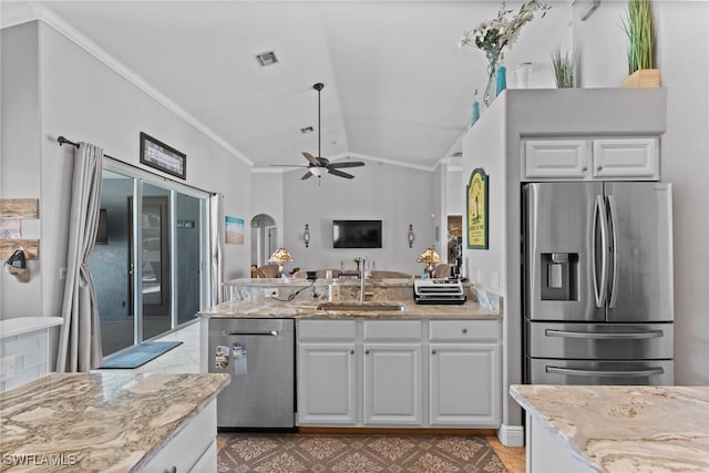 2640 SW 29th Ave, Cape Coral, FL 33914 - kitchen featuring a sink, stainless steel appliances, a peninsula, vaulted ceiling, and white cabinetry