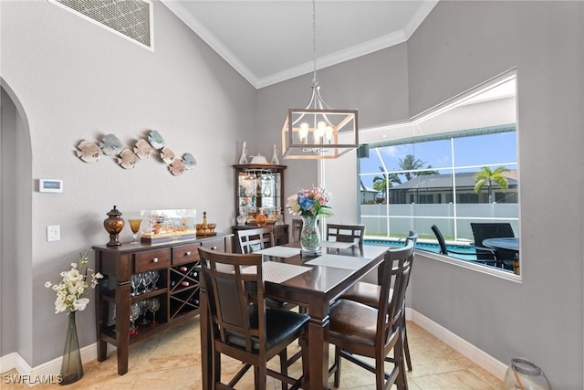 2640 SW 29th Ave, Cape Coral, FL 33914 - dining area featuring ornamental molding, arched walkways, a chandelier, baseboards, and light tile patterned floors