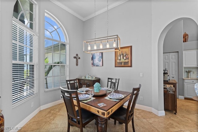 2640 SW 29th Ave, Cape Coral, FL 33914 - dining room featuring ornamental molding, arched walkways, a towering ceiling, baseboards, and light tile patterned flooring