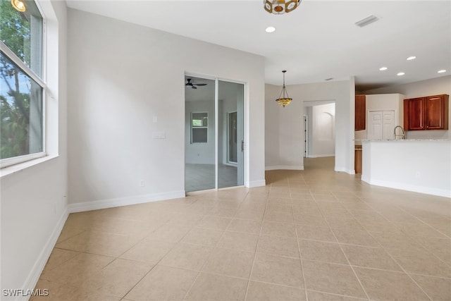 4220 12th Ave SE, Naples, FL 34117 - unfurnished living room with a ceiling fan, recessed lighting, baseboards, light tile patterned flooring, and a sink