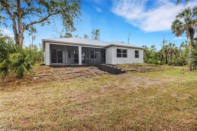 4220 12th Ave SE, Naples, FL 34117 - back of house featuring a sunroom, a yard, stucco siding, and metal roof
