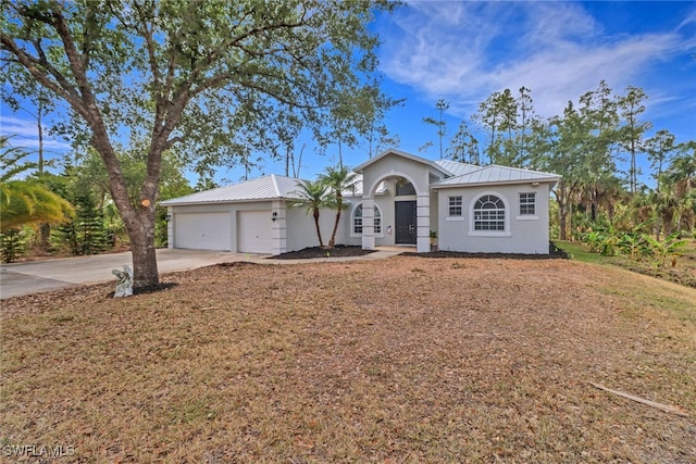 4220 12th Ave SE, Naples, FL 34117 - ranch-style home featuring metal roof, an attached garage, stucco siding, and driveway