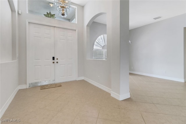 4220 12th Ave SE, Naples, FL 34117 - foyer entrance with light tile patterned floors, visible vents, baseboards, and arched walkways