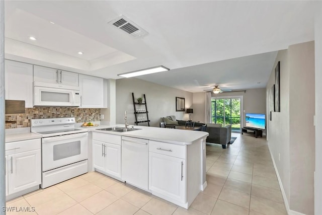 kitchen with visible vents, light countertops, open floor plan, white appliances, and a peninsula