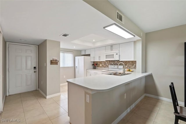 kitchen featuring light tile patterned floors, visible vents, tasteful backsplash, and white appliances